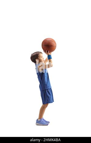 Scatto a tutto profilo di un ragazzo in una maglia blu che spara una basket isolata su sfondo bianco Foto Stock