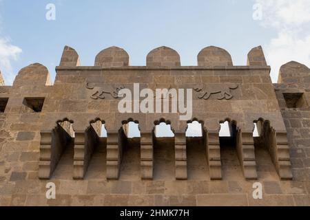 Il bassorilievo sulla torre di antiche fortificazioni è un simbolo medievale della città di Baku, Azerbaigian. Foto Stock