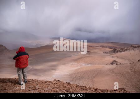 Una persona che affronta una tempesta al confine tra Cile e Argentina, nelle alte Ande di Copiapó, a 5000 metri sul livello del mare Foto Stock