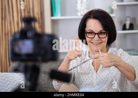 la donna anziana ha trasformato l'hobby di maglia nell'insegnamento da in linea Foto Stock