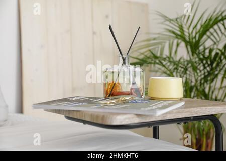 Diffusore a lamelle aromatiche con scomparto e tazza sul tavolo in camera da letto Foto Stock