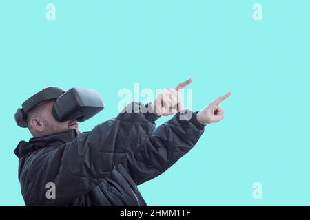 Un uomo che indossa occhiali vr punta il dito in avanti. Foto Stock