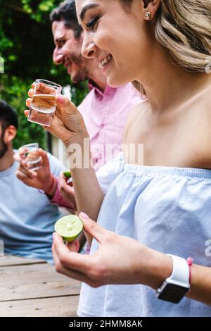 Gruppo di giovani amici latini incontro per birra, bevande michelada e cibo messicano preparare un toast nella terrazza del ristorante in Messico America Latina Foto Stock