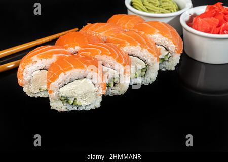 Il sushi sets Uramaki, California, Philadelphia, rotola su un piatto bianco. Menu per ristoranti, caffè. Su sfondo scuro riflettente. Spazio di copia Foto Stock