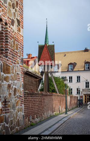 Edifici in pietra e campanile lungo una strada acciottolata nel centro della città di Lund Svezia Foto Stock