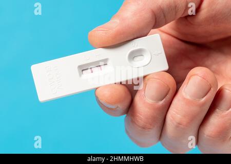 Mano che mostra il risultato positivo del test Covid-19 con il kit SARS COV-2 Rapid Antigen Test (ATK). Concetto di protezione infettiva del coronavirus. Foto Stock