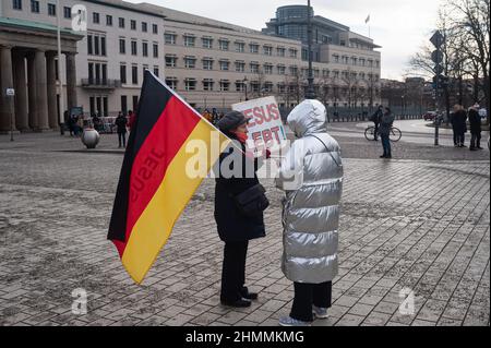 22.01.2022, Berlino, Germania, Europa - una donna ha una bandiera tedesca e un segno che legge Gesù Lebt (Gesù vive) in piazza Platz des 18 Maerz. Foto Stock