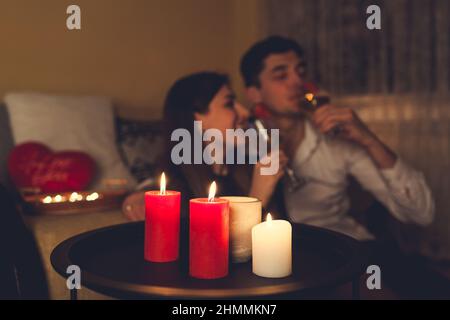 Giovane San Valentino coppia in amore bere champagne con fragole cena romantica con candele celebrare a casa di notte Foto Stock