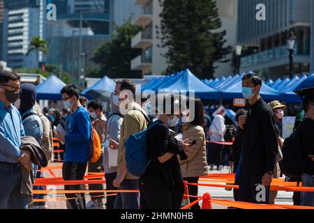 Hong Kong, Cina. 11th Feb 2022. Le persone si accodano in un centro di test temporaneo COVID a Edimburgo, nel centro di Hong Kong. Molti residenti si sono lamentati di dover riunirsi con migliaia di altre persone durante un'epidemia per partecipare a questi test obbligatori. Credit: Marc R. Fernandes /Alamy Live News Foto Stock