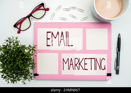 Firma che visualizza e-mail marketing. Parola per l'invio di un messaggio commerciale a un gruppo di mostrare utilizzando mail forniture ufficio su scrivania con tastiera e. Foto Stock