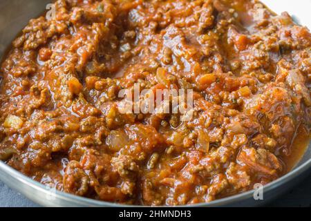 Fotografia gastronomica di una salsa di pasta di carne bolognese italiana in una padella di acciaio inossidabile - immagine ravvicinata Foto Stock