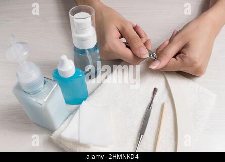 Una donna fa un manicure a casa. Attrezzi di manicure. Manicure bordato. Manicure pericoloso. Cura della casa, Spa, bellezza. Salone delle unghie Foto Stock