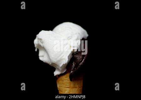 Gelato al limone e al cioccolato in un cono di waffle - sfondo nero Foto Stock