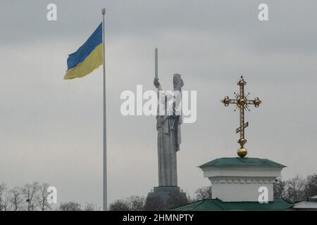 Kiev, Ucraina. 11th Feb 2022. La bandiera Ucraina vola vicino al Monumento della Motherland a Kiev il 11 febbraio 2022 in Ucraina. La capitale rimane calma mentre la Russia conduce esercitazioni militari congiunte con la Bielorussia a nord e intorno al confine con l'Ucraina. ''i cittadini americani dovrebbero partire, dovrebbe partire ora, ''Biden ha detto in un'intervista con NBC News. ''ci occupiamo di uno dei più grandi eserciti del mondo. Si tratta di una situazione molto diversa e le cose potrebbero impazzire rapidamente. (Credit Image: © Bryan Smith/ZUMA Press Wire) Foto Stock