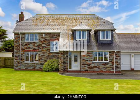 Tradizionale casa inglese con garage e prato verde Foto Stock