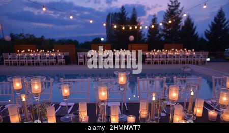 Belle decorazioni per la cerimonia di nozze, candele di moda, esterno sulla piscina. Foto Stock