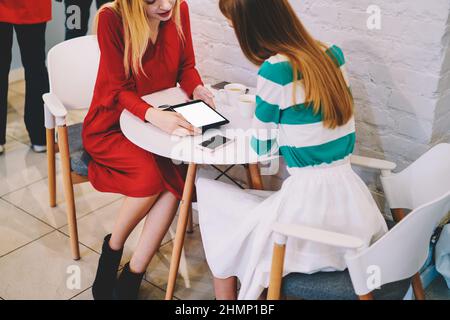 Donna che mostra un tablet al collega durante la pausa caffè Foto Stock