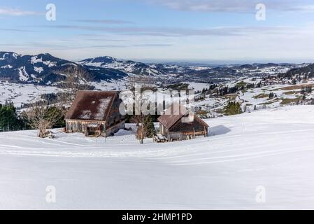 Chalet estivo isolato e scuderie in alto sulle Alpi svizzere ricoperte di neve fresca nei pressi di Bruelisau in Appenzell Foto Stock