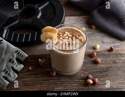 Snack body building per il guadagno muscolare. Agitare prima dell'allenamento con proteine del siero di cioccolato, fiocchi d'avena, banane e nocciole Foto Stock