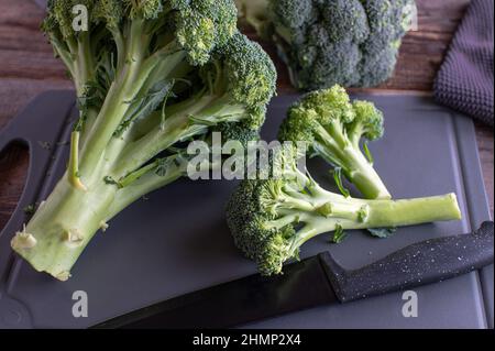 Broccoli su un tagliere con coltello Foto Stock