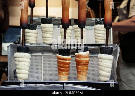 Repubblica Ceca, Praga, cucina Trdelnik, dolci tipici slovacchi. Preparazione di un trdelnik in un trdlo. Foto Stock