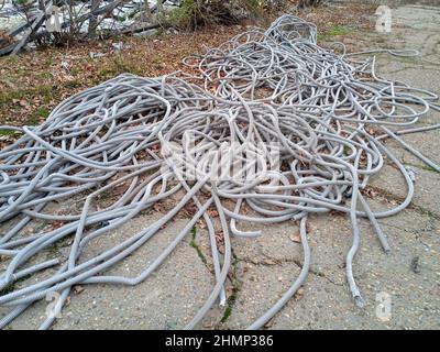 I tubi corrugati per il cablaggio elettrico si trovano in un cumulo a terra. Foto Stock