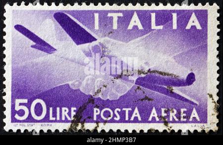 ITALIA - CIRCA 1947: Un francobollo stampato in Italia mostra l'aereo e le mani afferrato, circa 1947 Foto Stock