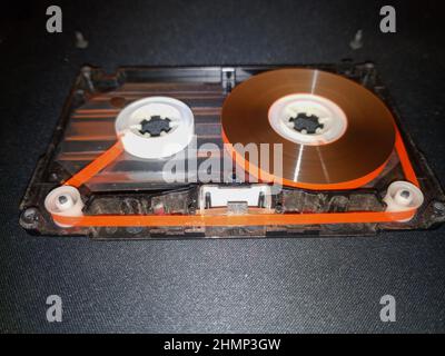 Cassetta audio smontata. Pellicola per cassetta in un contenitore aperto. Riparazione cassette vintage. Foto Stock