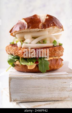 Salsa vegana di fusione asiatica con hamburger di ceci senza carne, patatine rapaci, mayo piccante, rochet e salsa al peperoncino Foto Stock