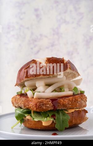 Salsa vegana di fusione asiatica con hamburger di ceci senza carne, patatine rapaci, mayo piccante, rochet e salsa al peperoncino Foto Stock