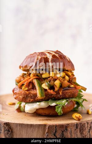 Bun morbido vegano fusion asiatico con hamburger di ceci senza carne, carote, zucchine, mayo, arachidi croccanti e foglie di razzo verde Foto Stock