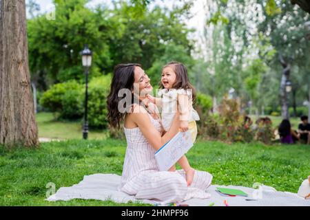 Madre che gioca con il bambino nel parco Foto Stock