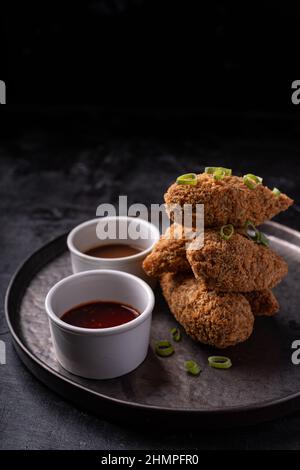 Bastoncini di jackfruit senza carne con salsa di sesamo calda dolce e salsa di barbecue vegano fusion asiatica Foto Stock