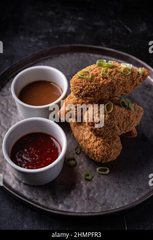 Bastoncini di jackfruit senza carne con salsa di sesamo calda dolce e salsa di barbecue vegano fusion asiatica Foto Stock