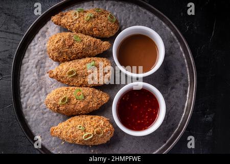 Bastoncini di jackfruit senza carne con salsa di sesamo calda dolce e salsa di barbecue vegano fusion asiatica Foto Stock