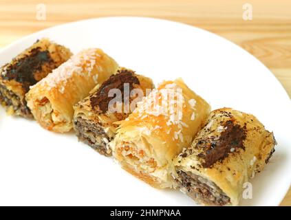 Piatto di deliziosi dolci Baklava a forma di rullo con sapori diversi Foto Stock