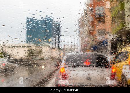 Le gocce si accumulano sul finestrino della vettura in condizioni di pioggia e la vista esterna dal vetro Foto Stock