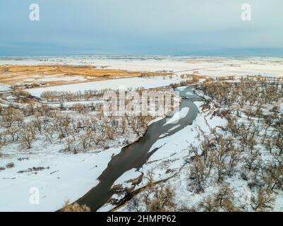 South Platte River con una diga di deviazione d'acqua sulle pianure del Colorado vicino a Milliken, vista aerea con paesaggio invernale Foto Stock