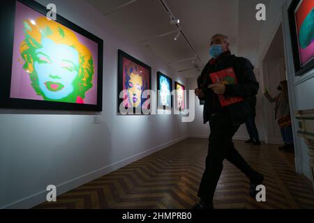 Madrid, Spagna. 11th Feb 2022. Un uomo visto camminare nella sala lungo la pittura laterale a Palacio de Santa Bárbara, durante la mostra. La mostra di Next Exhibition Company, si svolge un tour storico e professionale dell'artista Andy Warhol, un viaggio attraverso l'America nel 50s, 60s e 70s. Con la partecipazione di Art Motors e il sostegno della Camera di Commercio Italiana, la mostra sarà aperta al pubblico dal 12 febbraio al 5 giugno. Credit: SOPA Images Limited/Alamy Live News Foto Stock