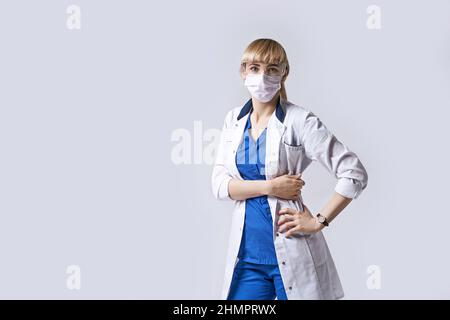 Sicuro medico donna indossare maschera protettiva viso. Verticale su sfondo grigio chiaro. Foto Stock