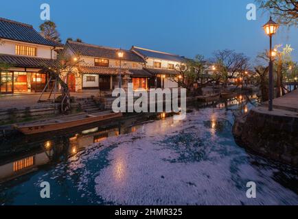 Vista serale dello storico quartiere storico di Bikan lungo il canale Kurashiki, in Giappone, con i tradizionali magazzini dalle pareti bianche riflessi Foto Stock