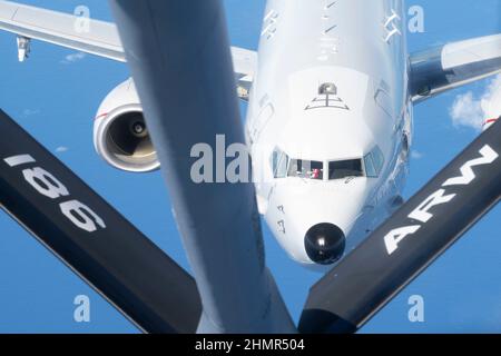 Una Royal Australian Air Force P-8A Poseidon assegnato alla base RAAF Darwin si avvicina a una US Air Force KC-135 Stratotanker assegnato a 506th Expeditionary Air Refilling Squadron schierato dalla Mississippi Air National Guard durante una missione di addestramento vicino al Mare delle Filippine 27 ottobre 2021. L'intento di questa missione era quello di qualificare più piloti RAAF P-8A al carro armato con la KC-135. (STATI UNITI Air Force foto di Airman 1st Class Kaitlyn Preston) Foto Stock