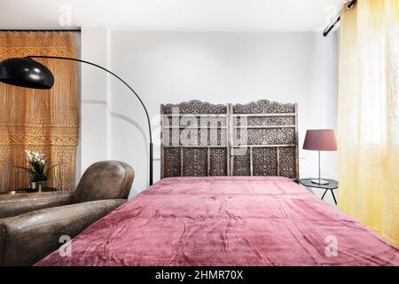 divani imbottiti in pelle marrone vintage con decorazioni arabiche e contemporanee, materasso con coperta rossa in studio per soggiorni brevi Foto Stock