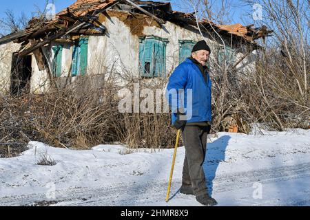 Zaitseve, Ucraina. 05th Feb 2022. Un vecchio uomo visto in piedi vicino ai 120 anni distrutti casa abbandonata nella periferia di Zaitseve.il presidente degli Stati Uniti Joe Biden ha invitato tutti i cittadini americani che rimangono in Ucraina a lasciare il paese immediatamente, citando le minacce crescenti di azione militare russa. Egli ha detto che non avrebbe inviato truppe per salvare gli americani se Mosca invade l'Ucraina. Il Cremlino dice che vuole far rispettare le 'linee rosse' per assicurarsi che il suo ex vicino sovietico non si unisca alla NATO (Organizzazione del Trattato Nord Atlantico) credito: SOPA Images Limited/Alamy Live News Foto Stock