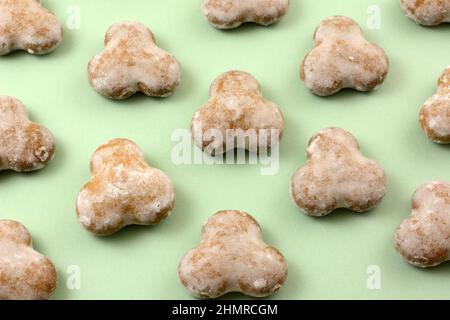 Biscotti di pan di zenzero glassato di menta in file su sfondo verde chiaro Foto Stock