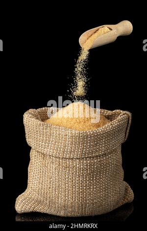 zucchero di canna di canna cadendo da paletta di legno in borsa di tela Foto Stock