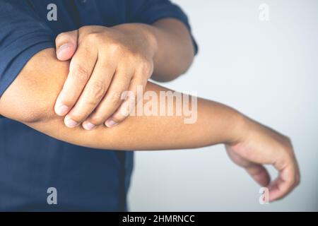 L'uomo è un gomito di dolore. Questi sintomi possono causare da sport, duro lavoro con il braccio. Primo piano. Foto Stock