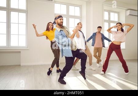 Gruppo di giovani e donne felici che hanno una lezione di danza in uno studio di danza moderna Foto Stock