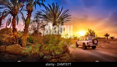 Viaggia, SUV percorre una strada nel deserto al tramonto, avventura di viaggio estrema nella natura Foto Stock