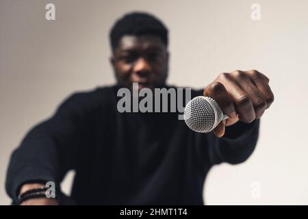 persona di colore che tiene espositore microfono studio - primo piano scatto. Foto di alta qualità Foto Stock